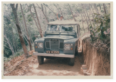 A land rover making its way down a dusty dirt road.
