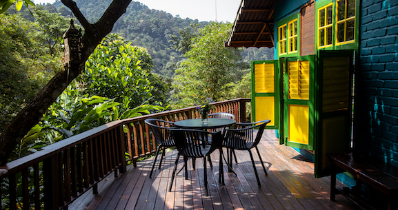 A wooden deck with a table and chairs, perfect for outdoor dining and relaxation.