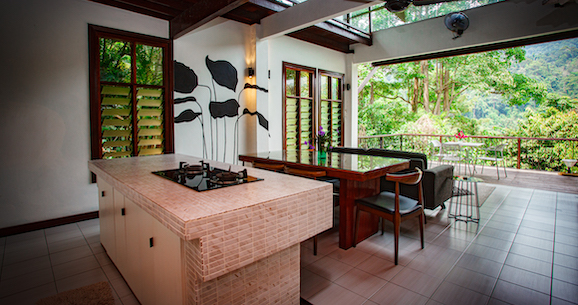 A kitchen in a house with a table and chairs and a view of the trees.